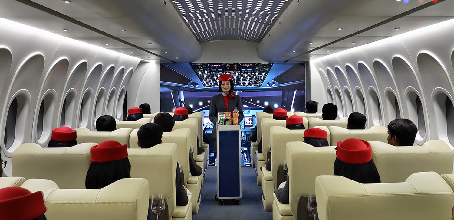 Cabin crew trainees practicing meal service inside Airbus A330 mock aircraft at Wings Institute Vadodara
